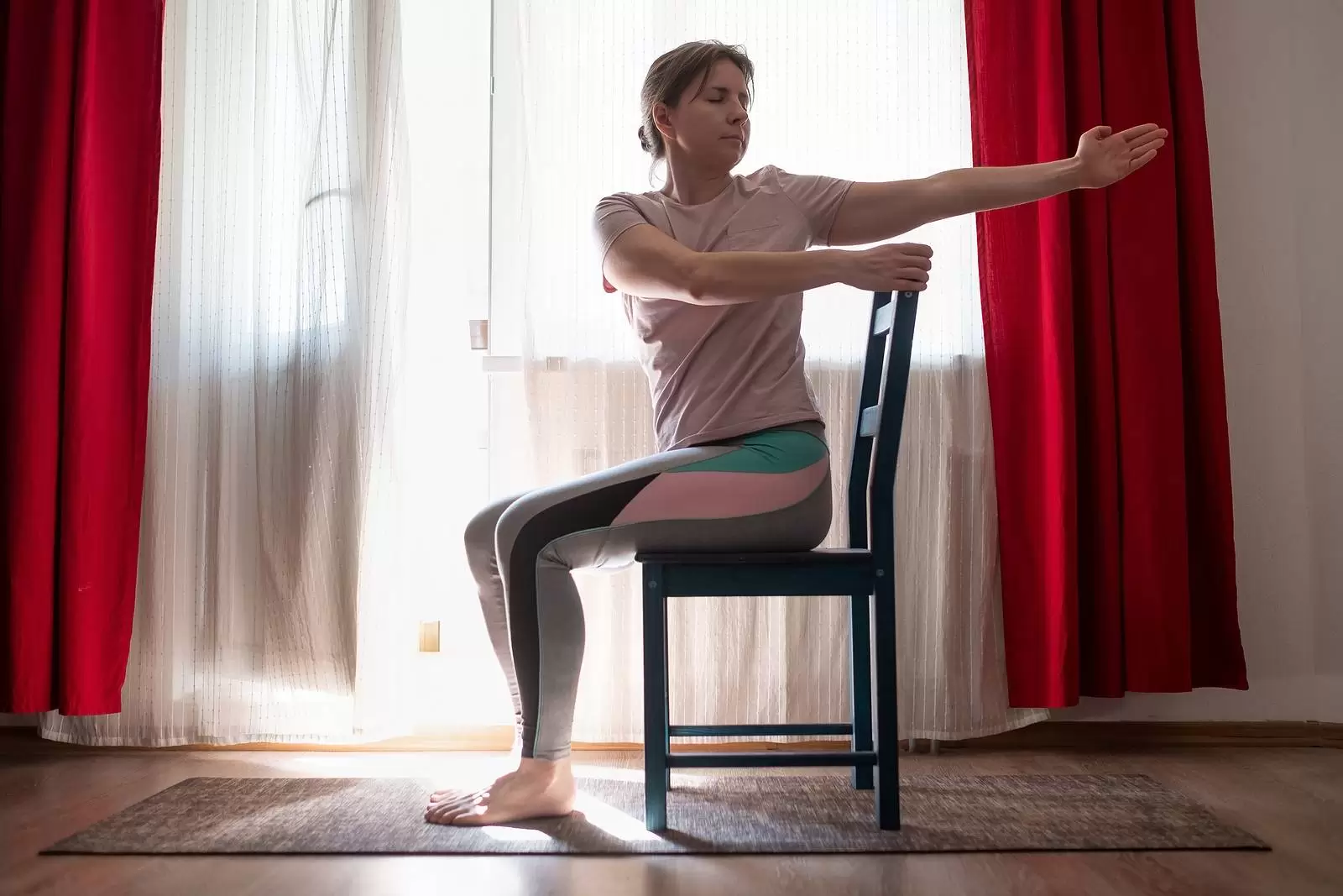 Woman working out doing yoga or pilates exercise using chair